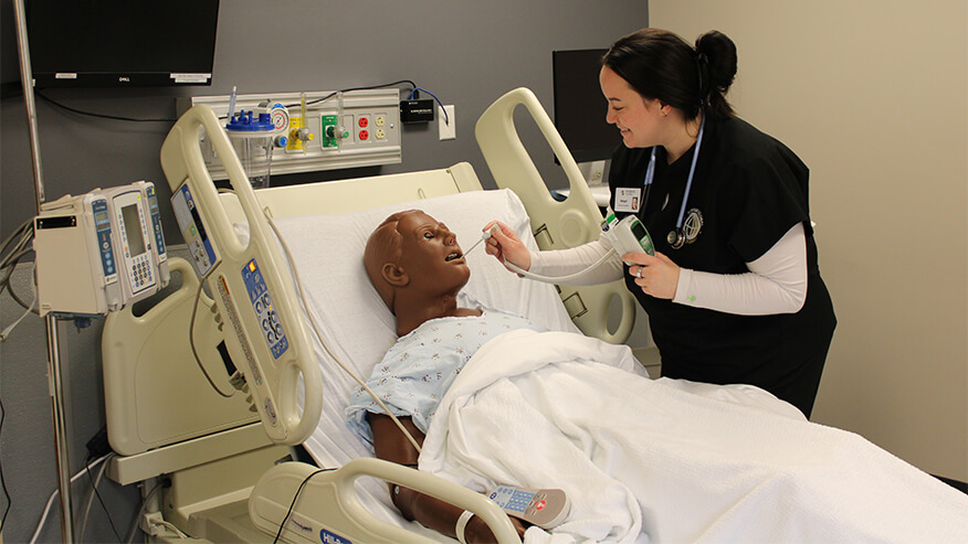 alt: Purdue Global nursing student Abigail Graham practices patient assessment skills at Purdue Global’s simulation center in Council Bluffs, Iowa. 