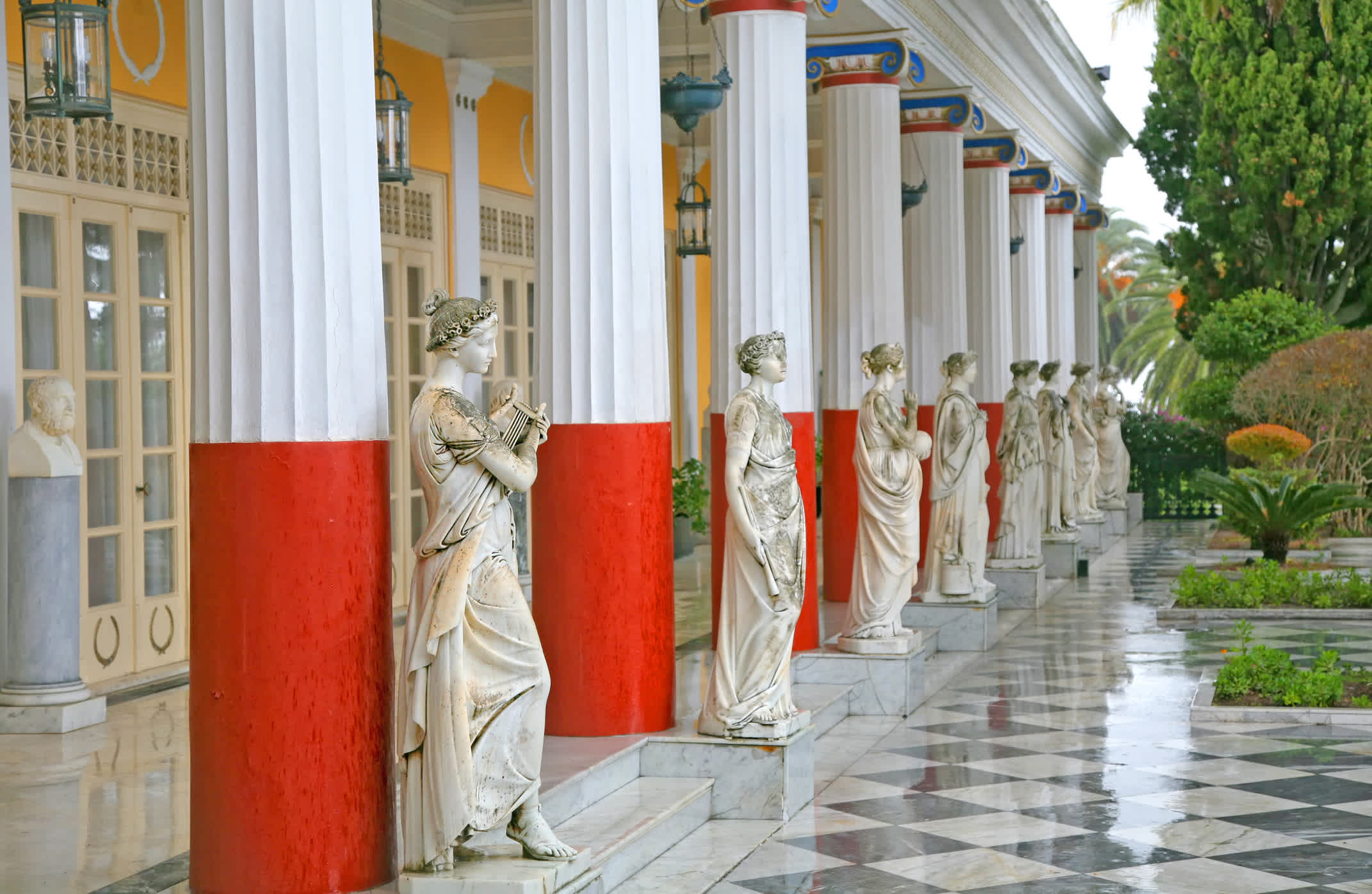 Vue sur les colonnes blanches et rouges avec des sculptures du palais Achillion à Corfou, Grèce