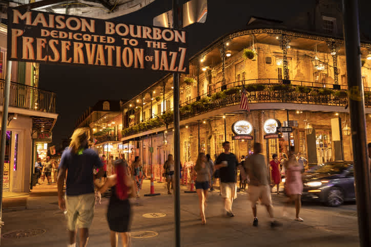 Passanten schlendern an der berühmten Preservation Hall Jazz Bar im French Quarter auf der Bourbon Street vorbei, einer der beliebtesten Orte, die Sie während Ihrer Reise nach Louisiana besuchen sollten.
