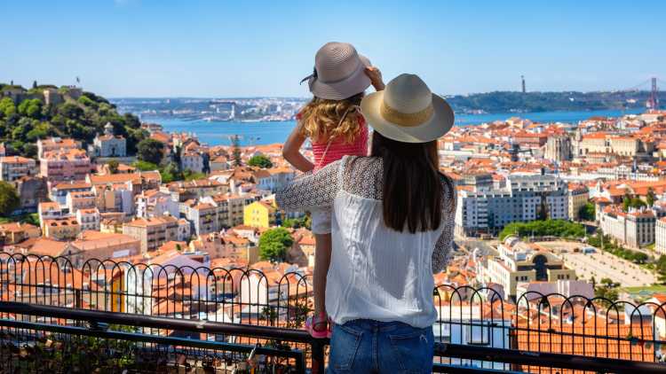 Eine Mutter und Tochter genießen den Blick auf das Stadtbild von Lissabon, Portugal. 