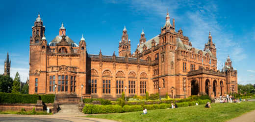 People enjoying sunny weather outside the front of the Kelvingrove Art Gallery and Museum in Glasgow
