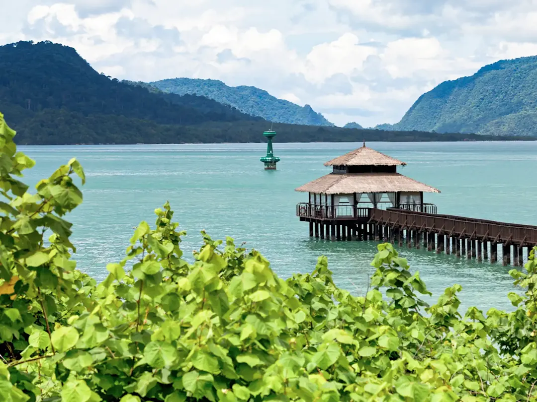 Tropischer Steg mit Pavillon über türkisfarbenem Wasser. Malaysia.