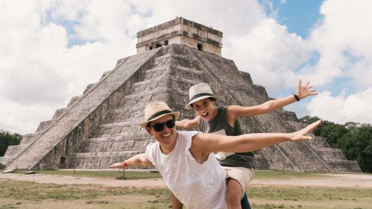 Mutter und Tocher vor einem Maya-Tempel während eines Familienurlaubs in Mexikpo

