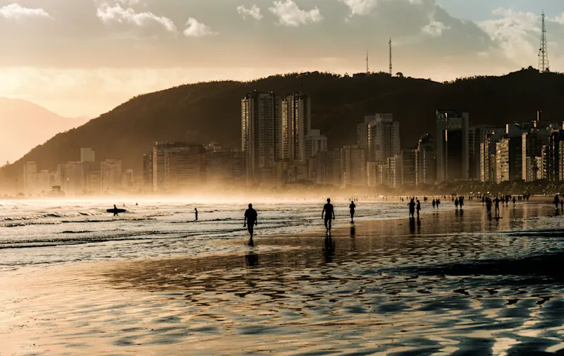 Strand Santos Sao Paulo Brasilien Wanderer am Strand bei Sonnenuntergang in Santos, São Paulo, Brasilien