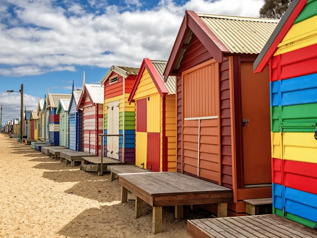 Reihe bunter Strandhütten am Brighton Beach bei sonnigem Wetter. Melbourne, Victoria, Australien.