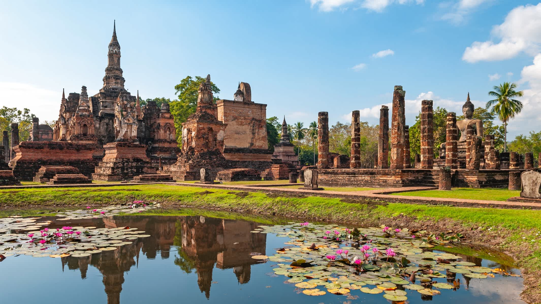 Vue sur les ruines de Sukhothai avec un petit étang au premier plan