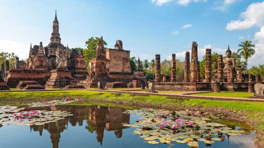 Vue sur les ruines de Sukhothai avec un petit étang au premier plan