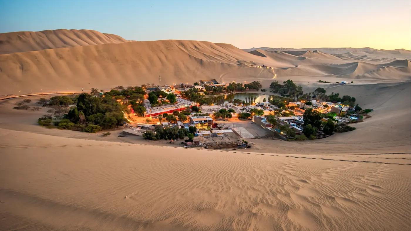Ica, oasis, Peru Oase inmitten riesiger Sanddünen in der Abenddämmerung. Ica, Ica, Peru.