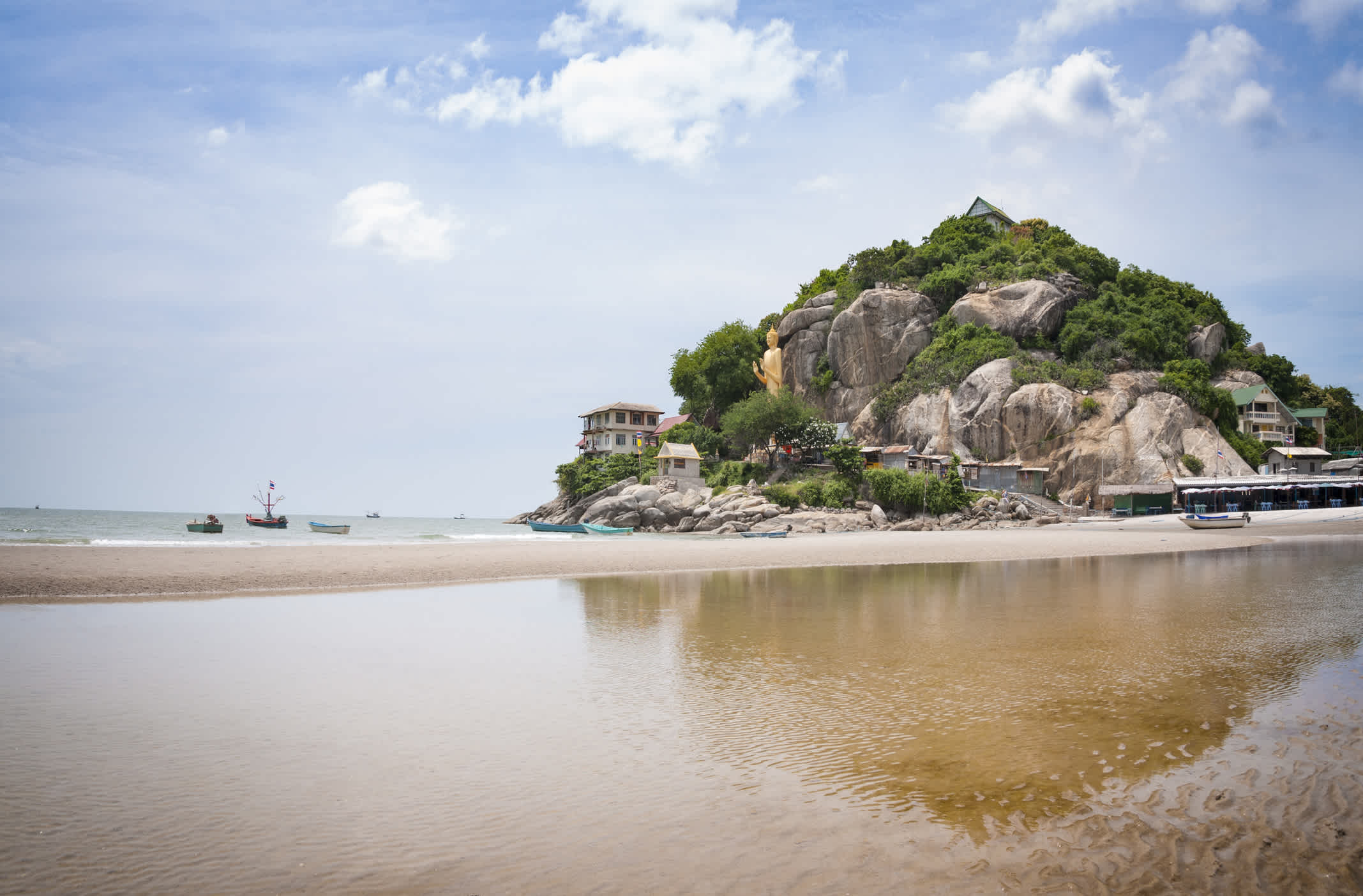 La plage de Hua Hin avec une grande statue dorée de Bouddha debout en arrière-plan, Hua Hin en Thaïlande