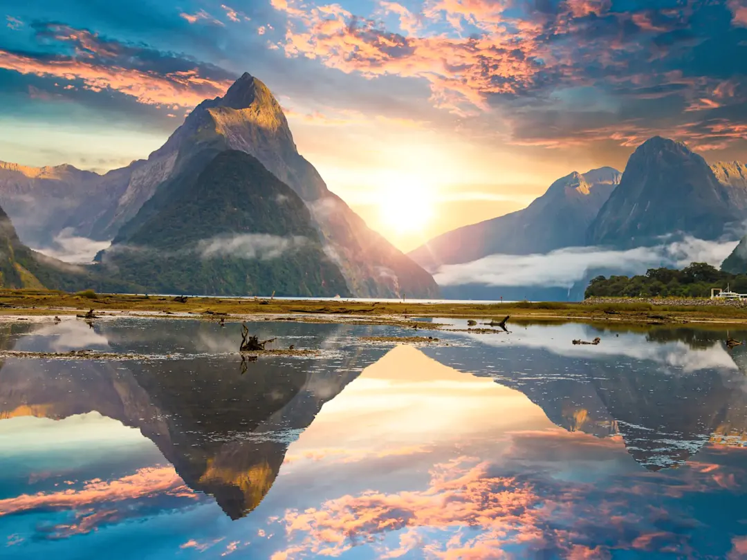 Spiegelsee mit Bergen bei Sonnenaufgang. Milford Sound, Southland, Neuseeland.
