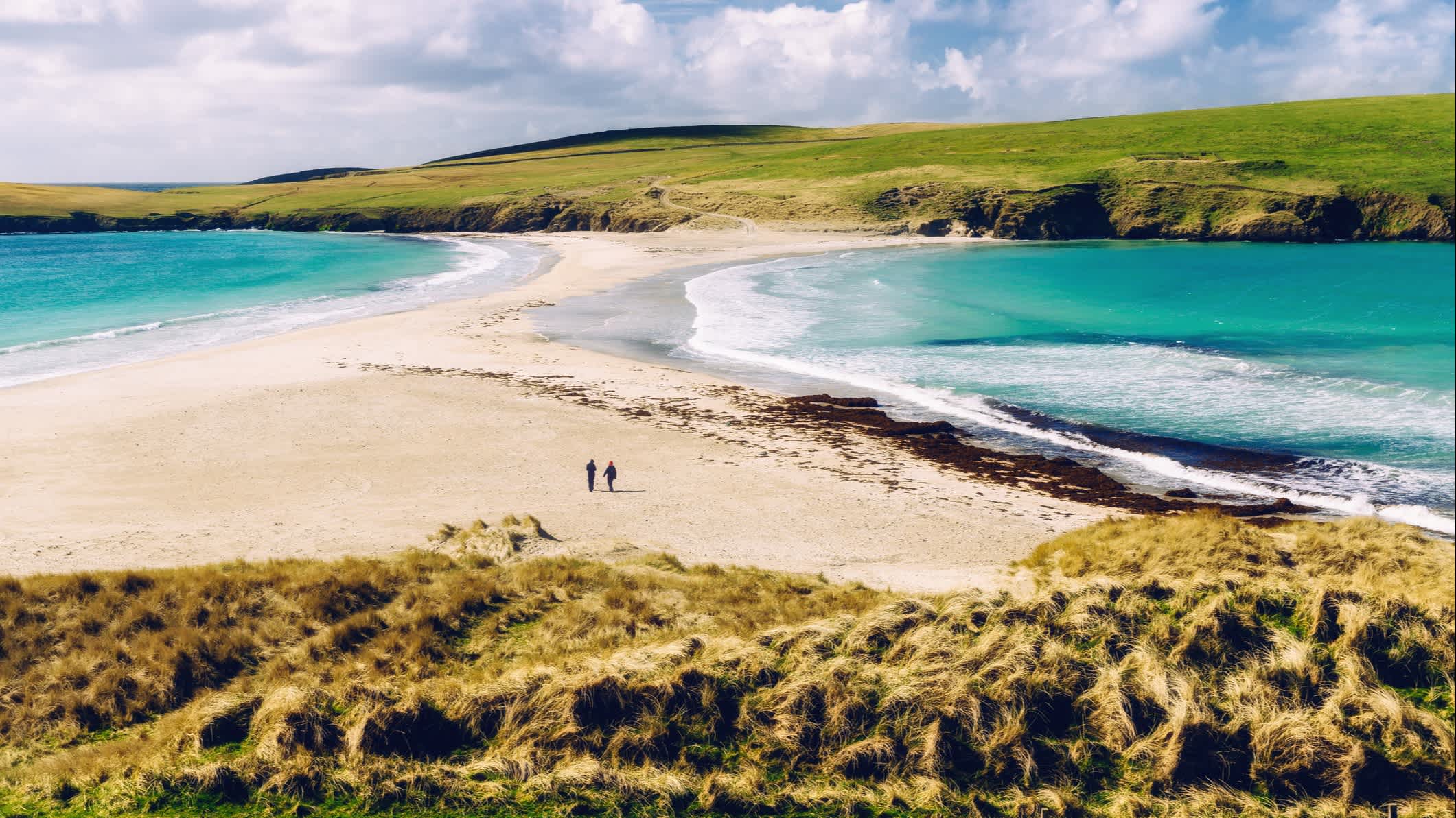 Deux personnes sur la plage de St Ninians Isle, Shetland, Ecosse