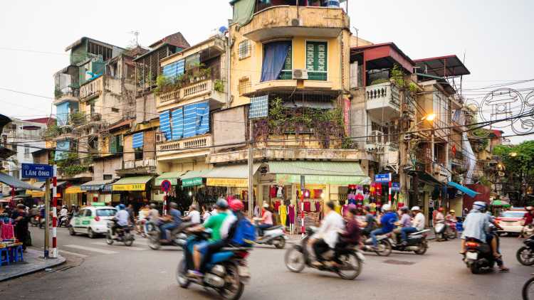 A_weg_kruispunt_in_Hanoi_Vietnam_met_motors_scooters_opgefleurd
