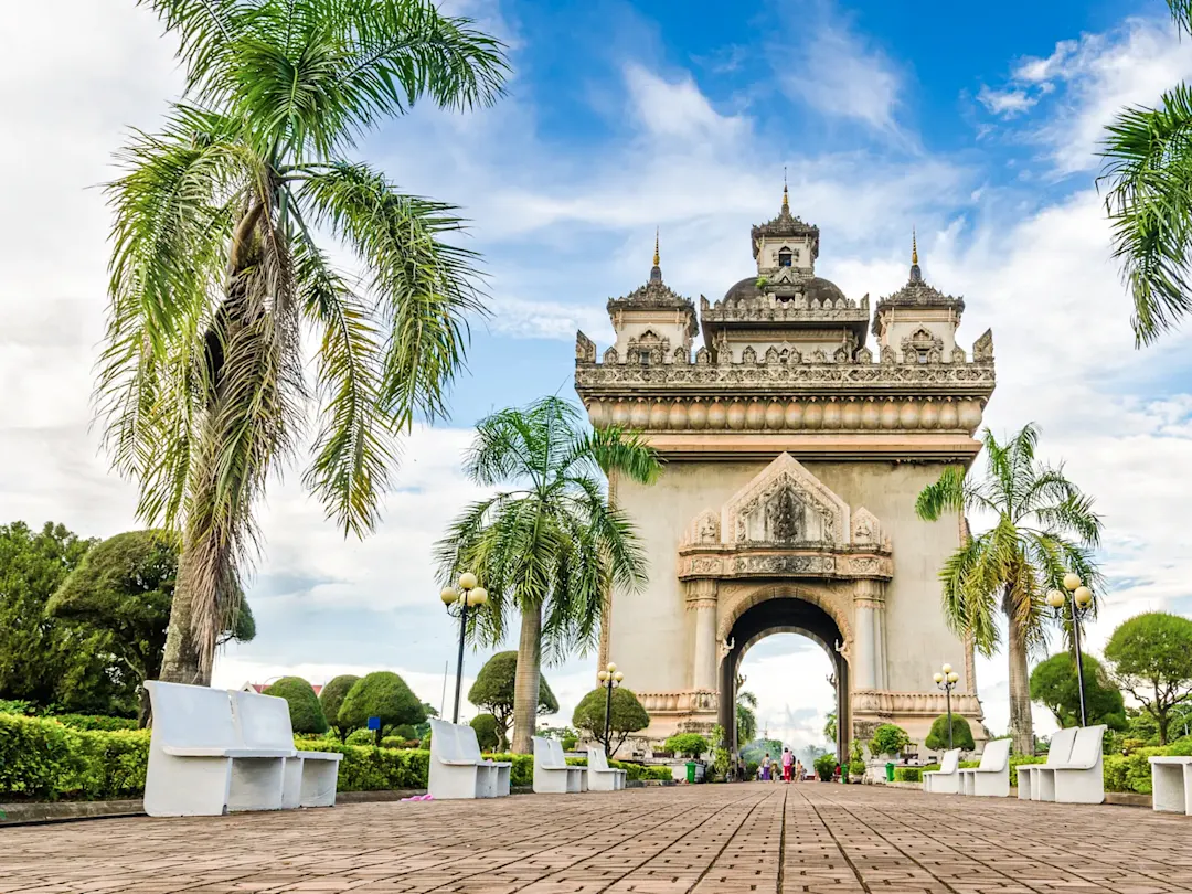 Triumphbogen mit Palmen und gepflastertem Weg. Patuxai, Vientiane, Laos.