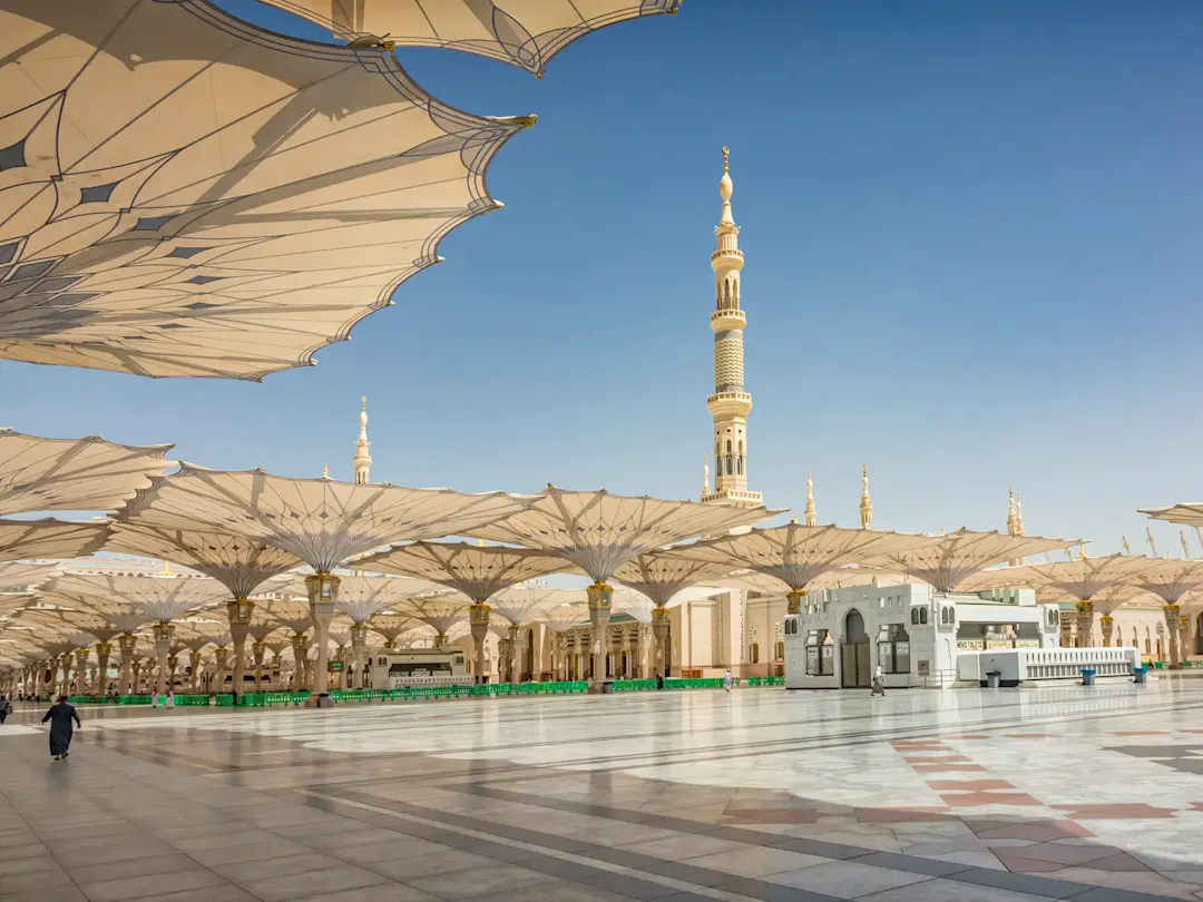 Moschee mit großen Sonnenschirmen auf dem Platz. Medina, Al-Madina, Saudi-Arabien.
