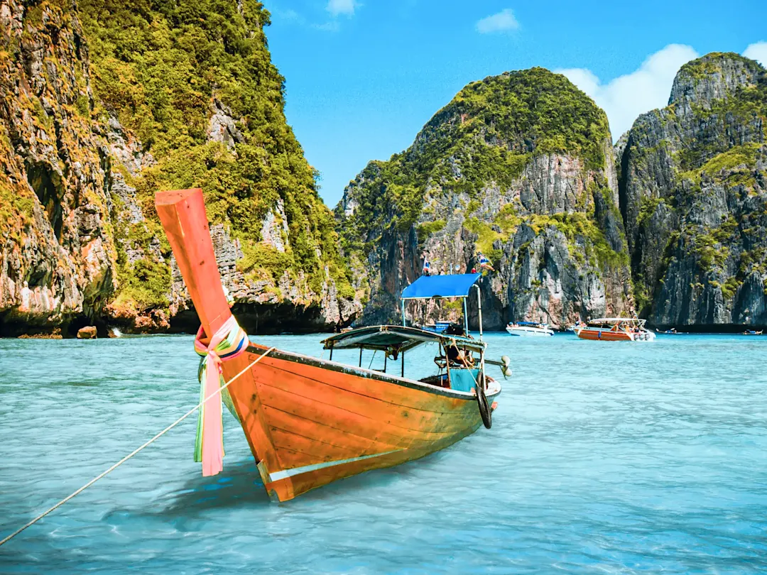 Longtail-Boot vor Kalksteinfelsen und klarem Wasser. Maya Bay, Krabi, Thailand.