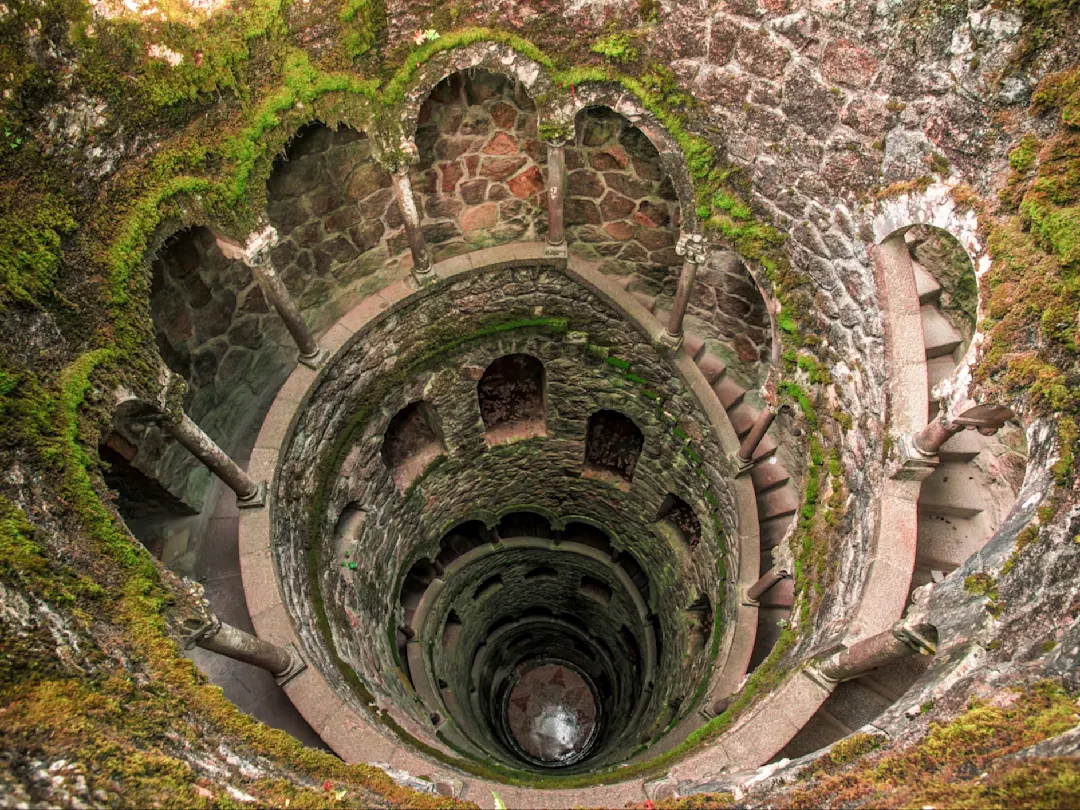 Spiralförmige unterirdische Wendeltreppe im mystischen Initiationsbrunnen von Quinta da Regaleira. Sintra, Lissabon, Portugal.