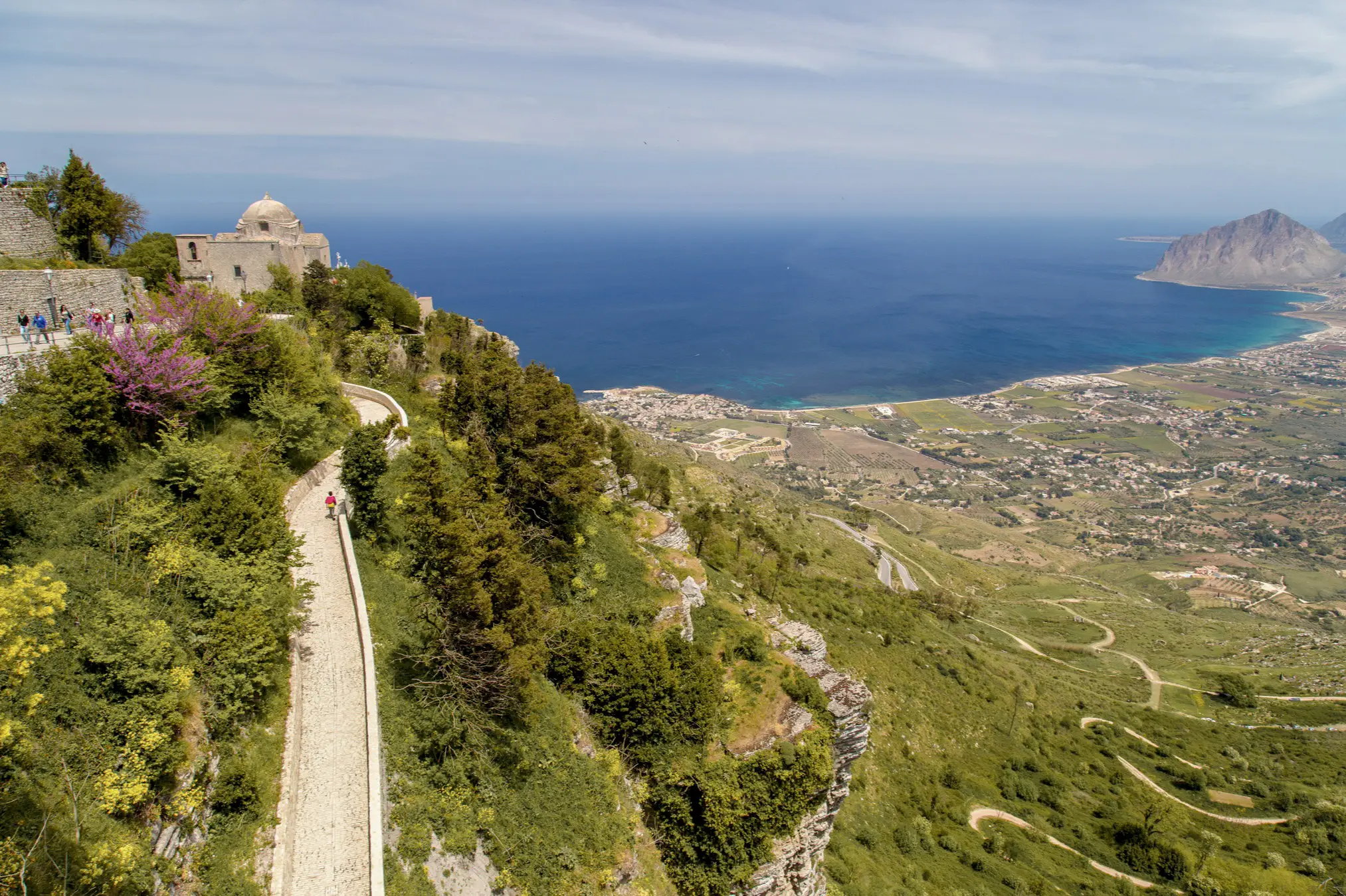 Blick auf eine alte Bergstraße, die hoch zum Ort Erice führt mit dem Meer im Hintergrund