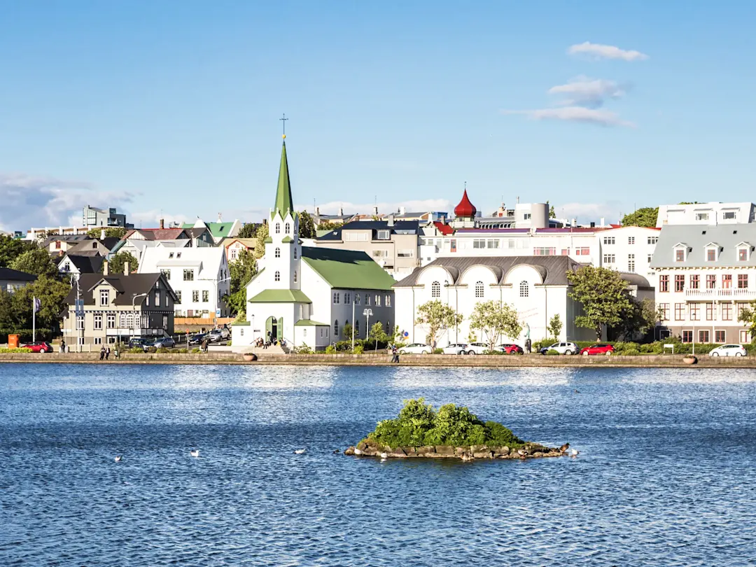 Stadtblick mit See und Kirche im Sonnenschein. Reykjavík, Island.