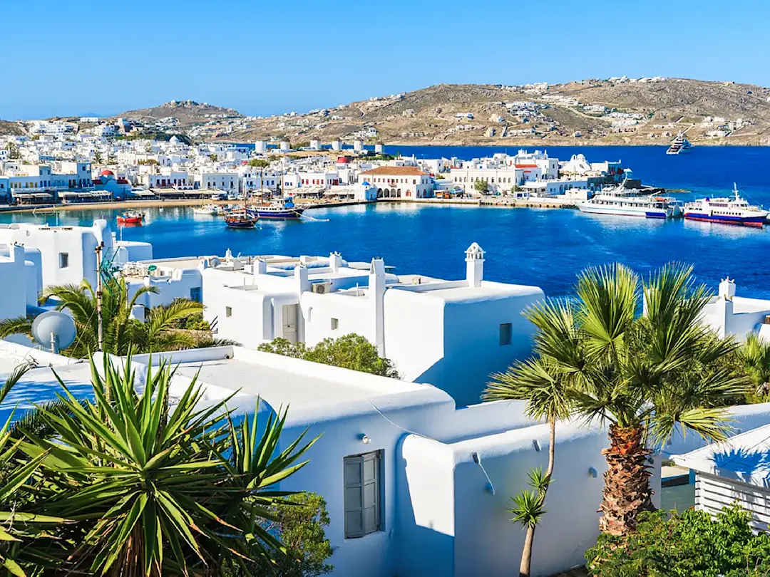 Küstenstadt mit weißen Gebäuden, blauen Akzenten und Hafen mit Booten. Mykonos, Griechenland.