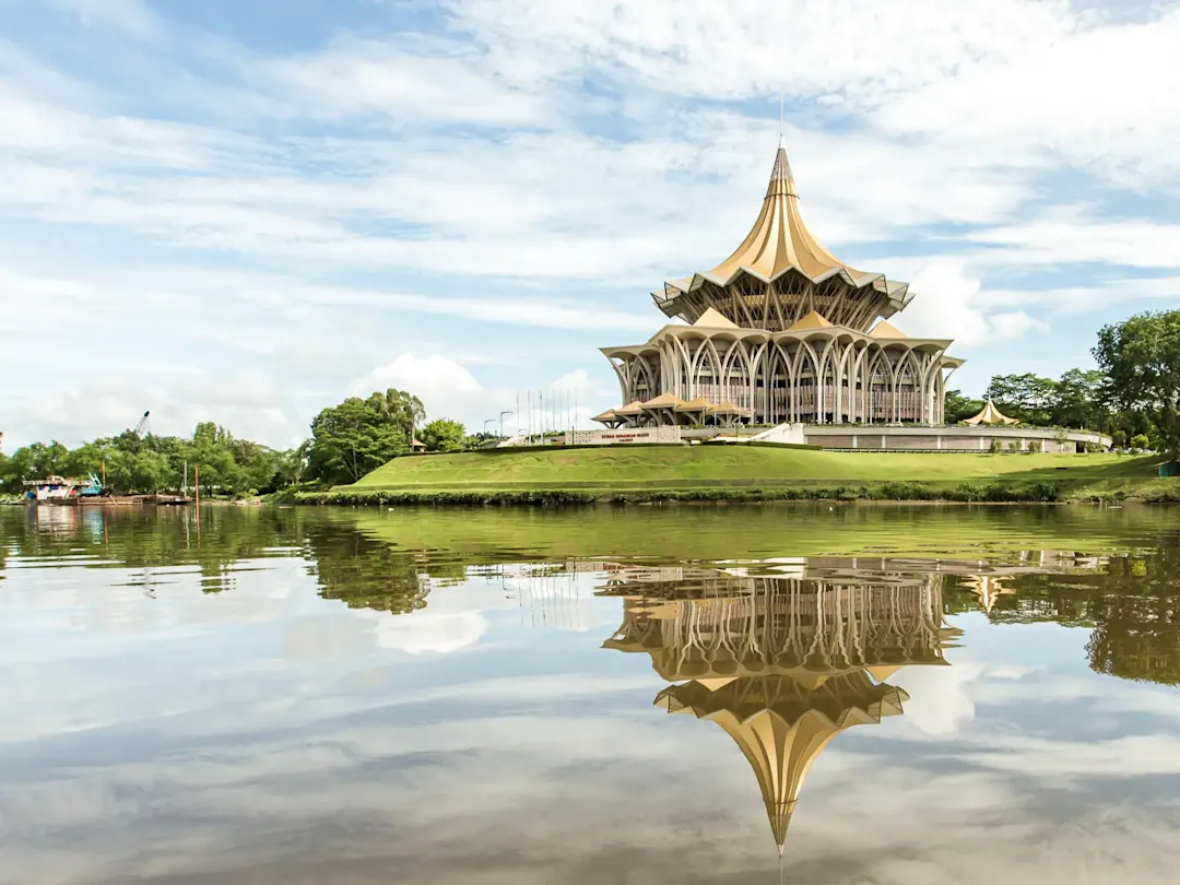 Modernes Parlamentsgebäude mit Reflexion im Fluss. DUN-Gebäude, Kuching, Sarawak, Malaysia.