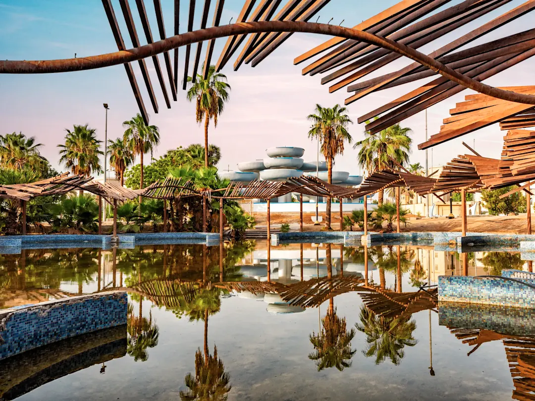 Verlassener Wasserpark mit Palmen und Spiegelung im Wasser. Jeddah, Mekka, Saudi-Arabien.
