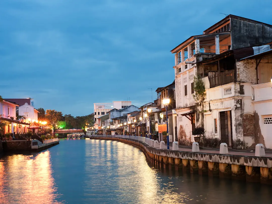 Historische Häuser und Uferpromenade bei Abendbeleuchtung. Malakka-Fluss, Malakka, Malaysia.