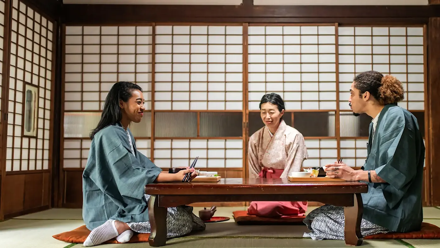 Japon, Tokyo, vacances de noces Un couple en vêtements traditionnels japonais mangeant autour d'une table en bois. Tokyo Ryokan, Japon.