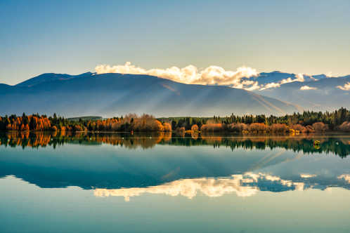 Die schneebedeckten Gipfel der Berge spiegeln sich auf dem ruhigen Wasser der Ruderstrecke auf dem Lake Ruataniwha auf der Südinsel Neuseelands.