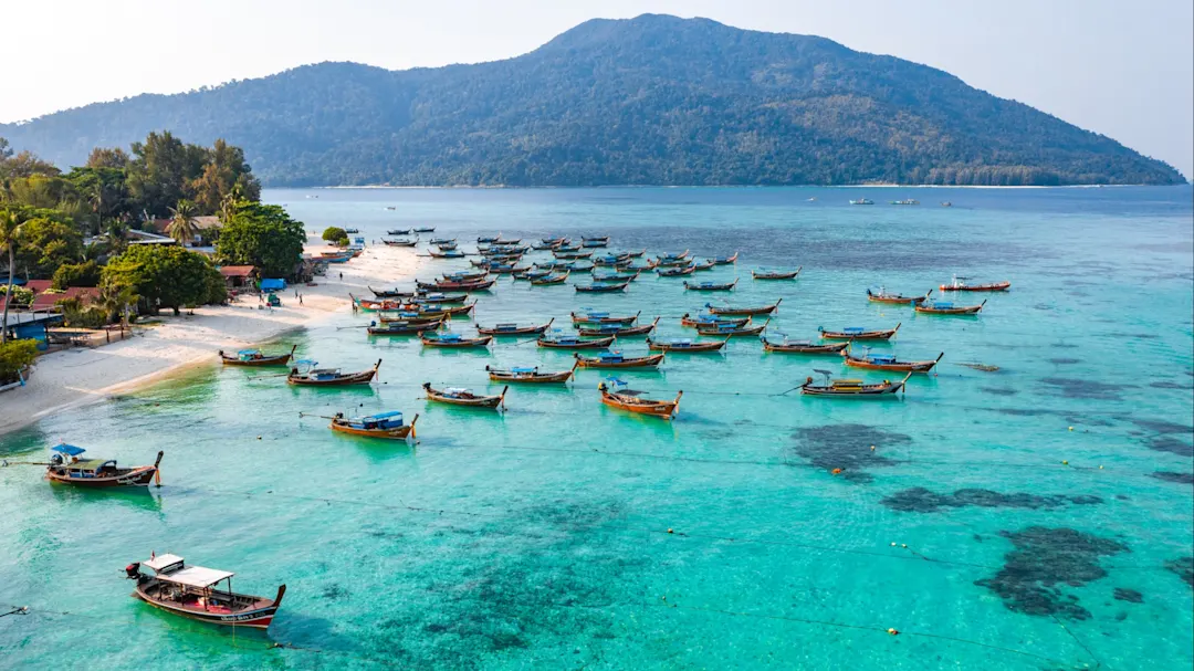 Luftaufnahme von Sunrise Beach mit Longtail-Booten in Koh Lipe, Thailand.