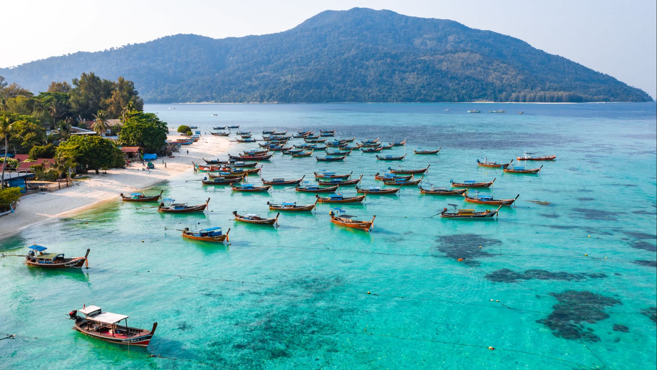 Luftaufnahme von Sunrise Beach mit Longtail-Booten in Koh Lipe, Thailand.