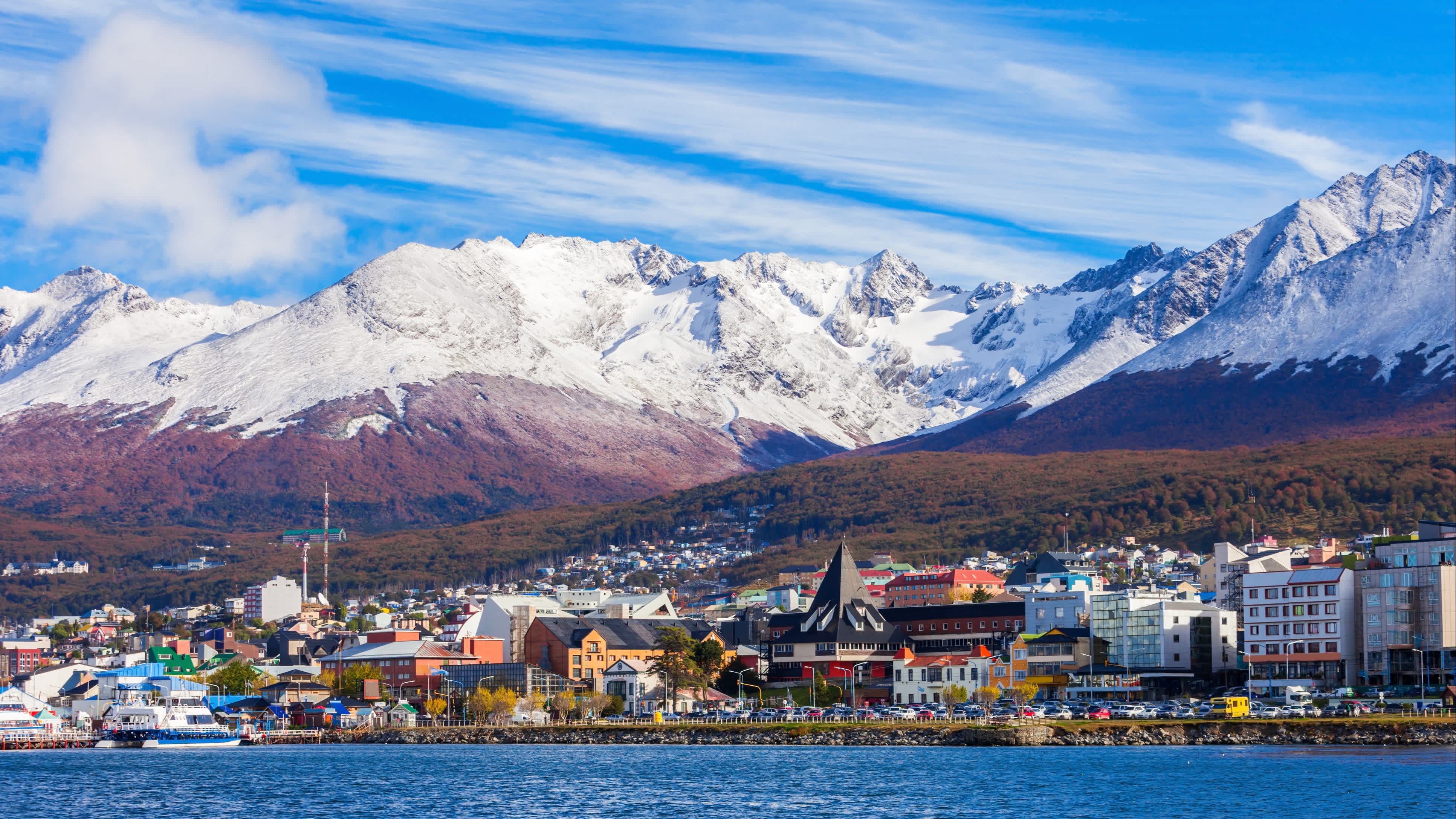 Vue panoramique de la ville d'Ushuaïa avec ses montagnes enneigées en arrière-plan depuis un bateau pendant un voyage à Ushuaïa, Argentine