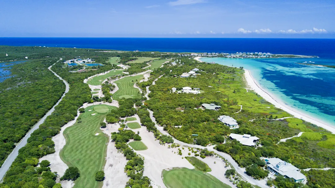  Ein Golfplatz schlängelt sich durch grüne Landschaften entlang der türkisfarbenen Küste. Bahamas.