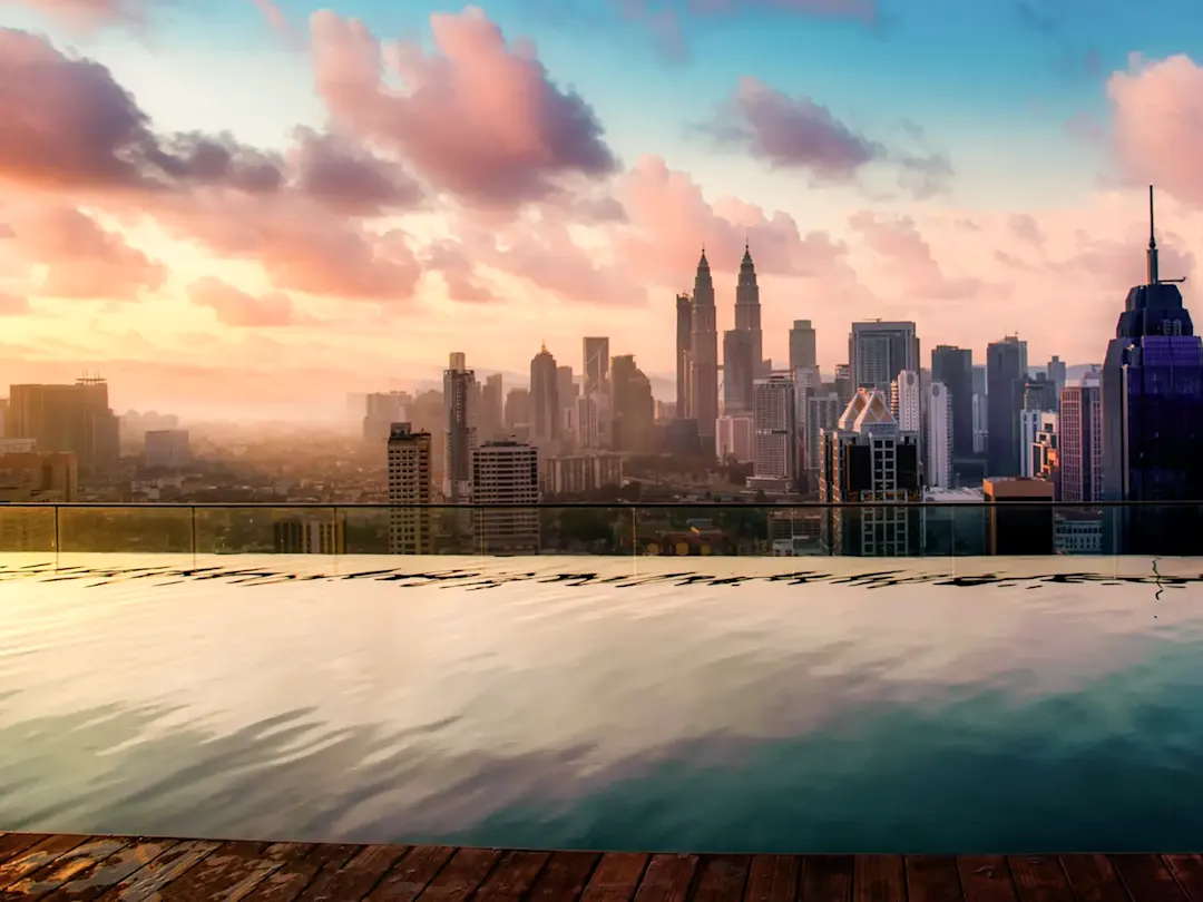 Skyline mit Petronas Towers und Poolblick bei Sonnenaufgang. Infinity-Pool, Kuala Lumpur, Malaysia.