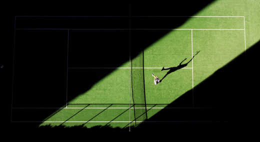Un joueur de tennis en train de s'entraîner sur un court de tennis sur gazon.