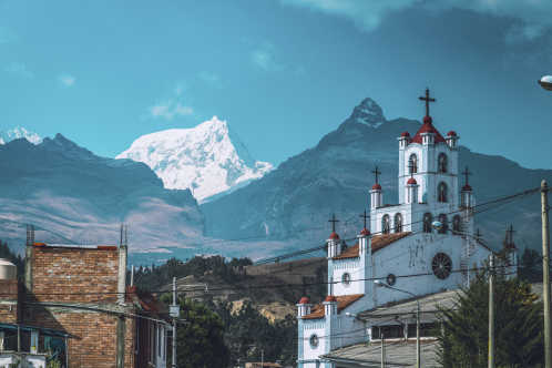 Eine Kirche vor dem Andengebirge Cordillera Blanca in der Stadt Huaraz, Peru.