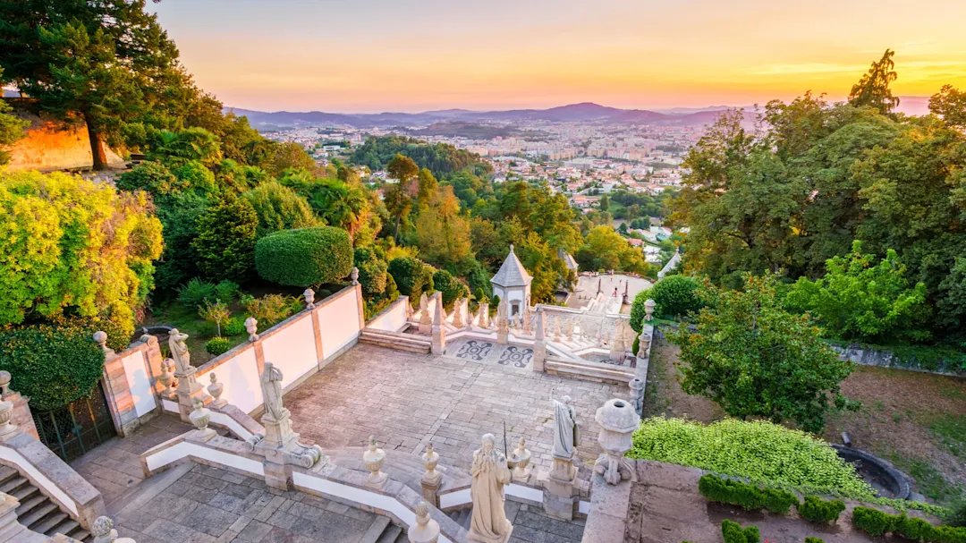 Portugal, Braga, Santuário do Bom Jesus do Monte Blick vom Santuário do Bom Jesus do Monte auf die Stadt Braga bei Sonnenuntergang umgeben von Bäumen
