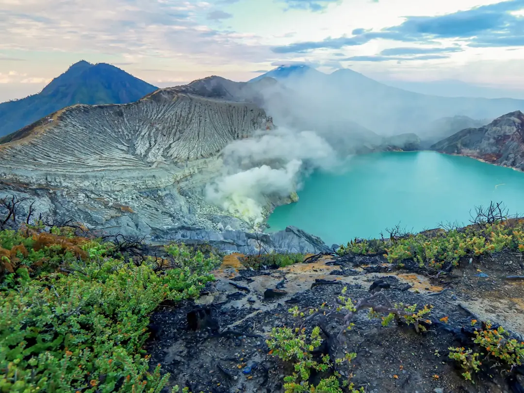 Vulkanischer Krater mit türkisfarbenem See und Rauch. Ijen, Java, Indonesien.