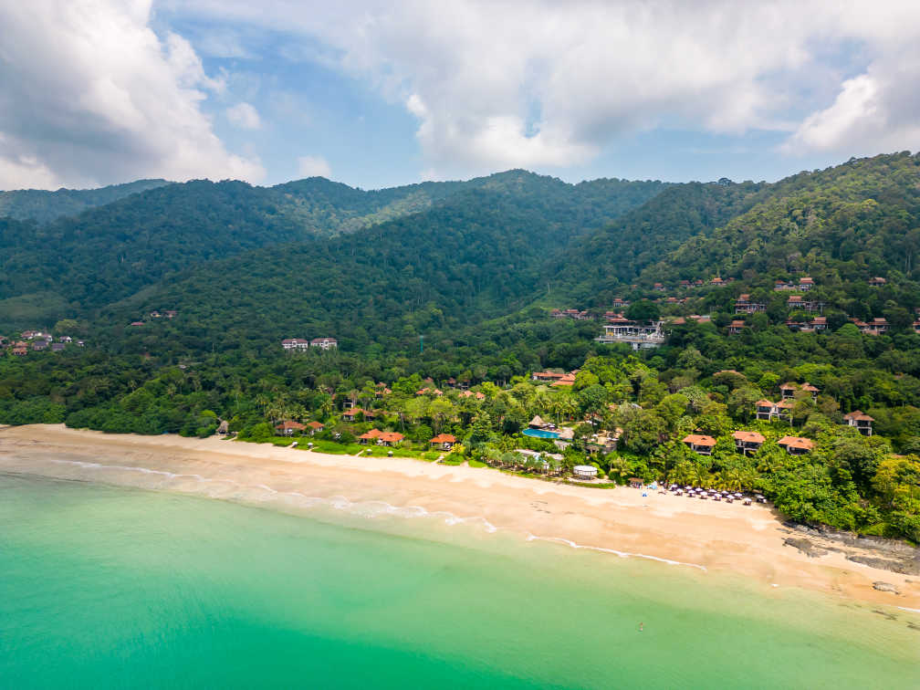 Drohnenaufnahme der Bambusbucht und des Strandes auf der Insel Koh Lanta, Thailand. Tropischer Wald in der Nähe des felsigen Strandes und weißer Sand mit türkisfarbenem Wasser