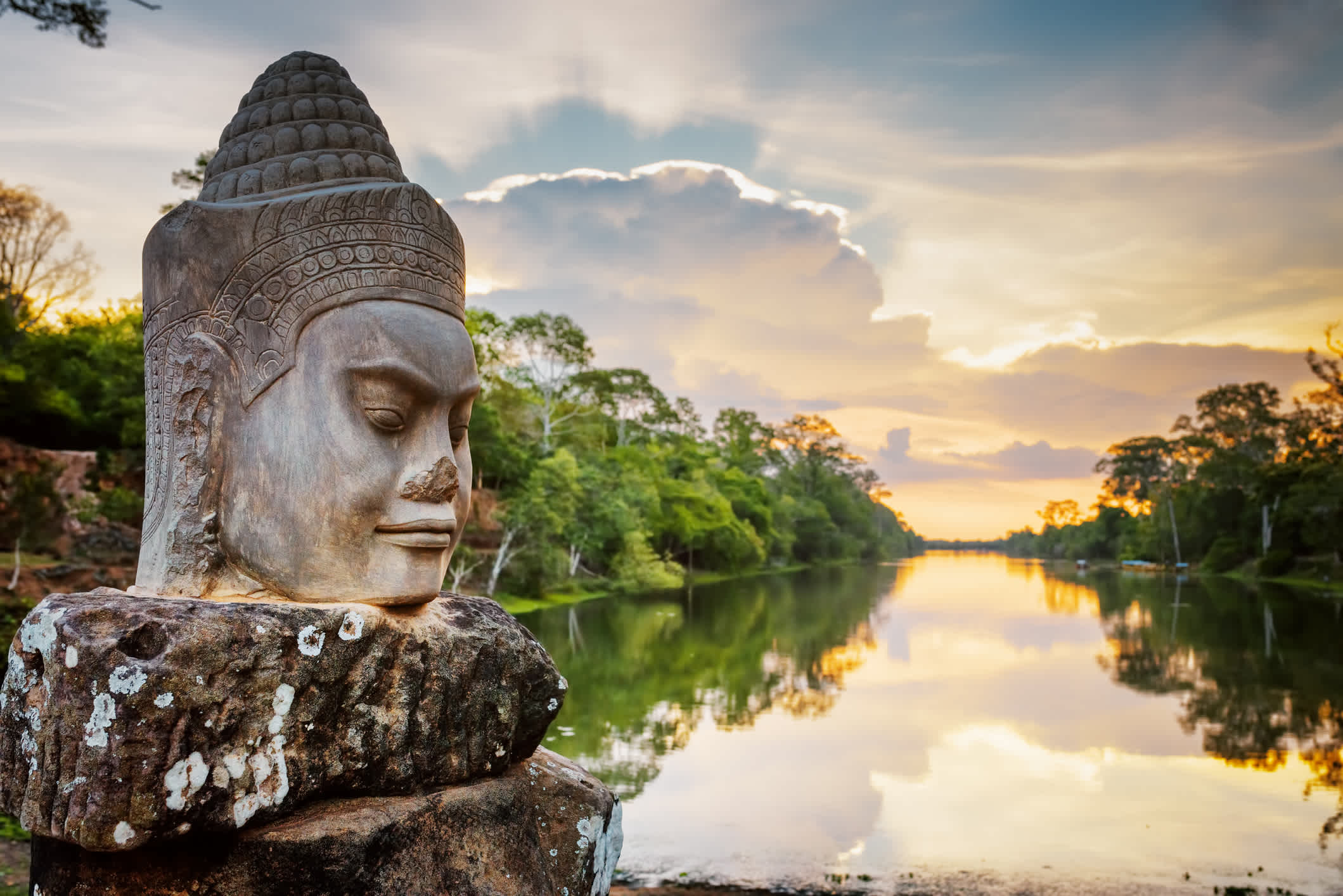 Vue d'une statut au bord de l'eau de Angkor Thom au coucher du soleil, à Siem Reap, Cambodge.
