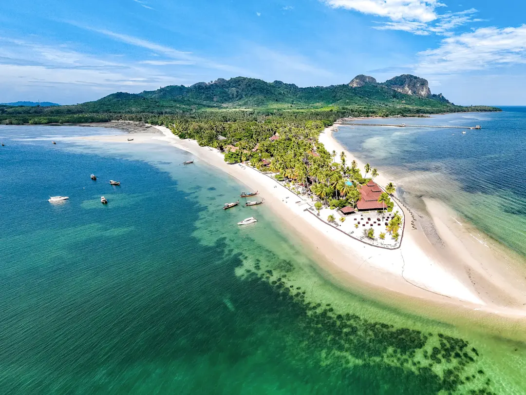 Grüner Hügel und ruhiger Sandstrand in tropischer Umgebung. Koh Chang, Thailand.