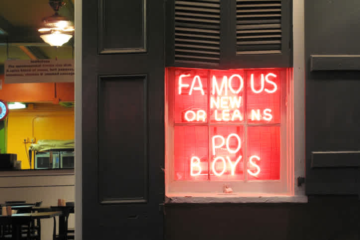 Ein Restaurantschild, auf dem Sie eines der beliebtesten Gerichte von New Orleans, Po Boy, genießen können. Ein Muss während Ihrer Reise nach Louisiana.