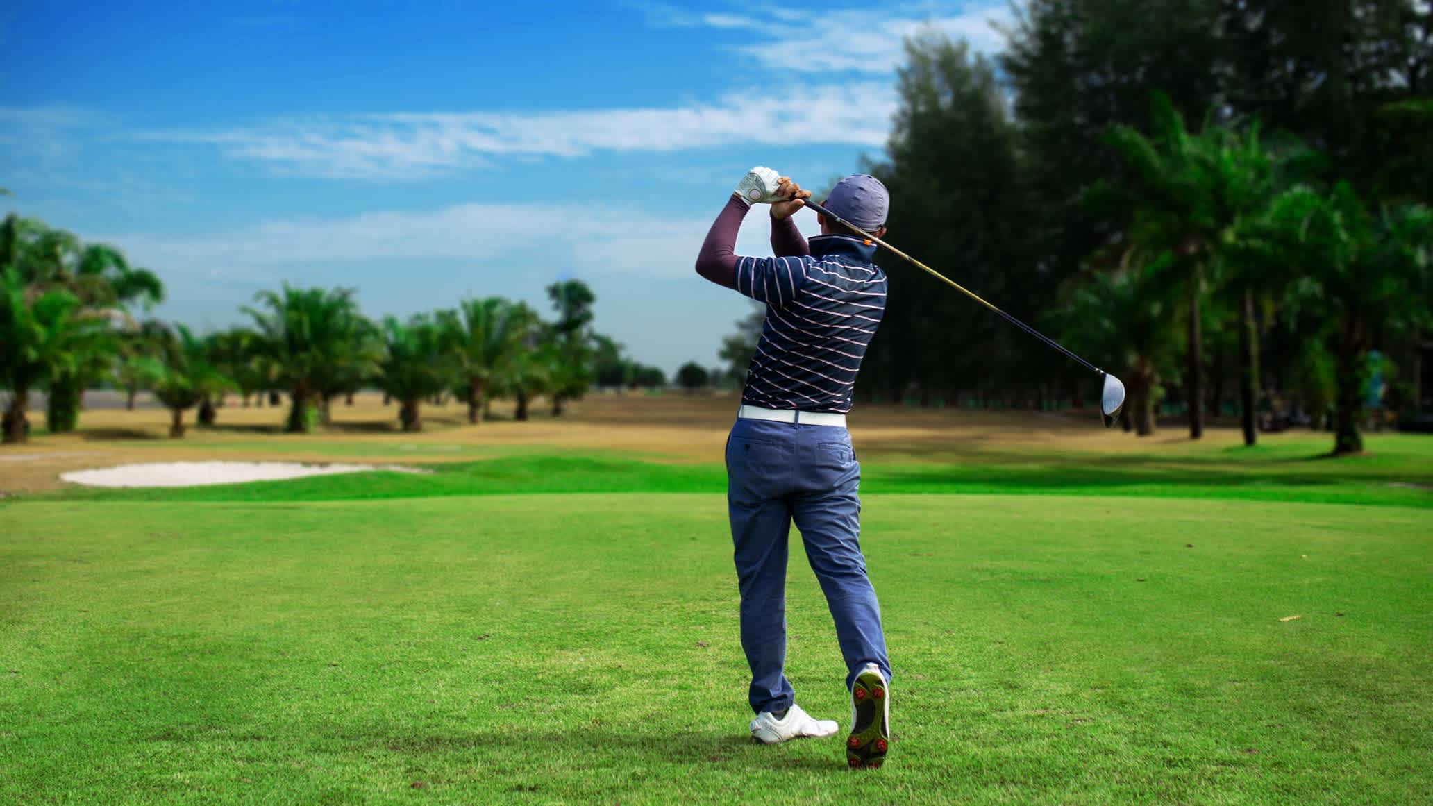 Un joueur de golf en plein parcours en Thaïlande.