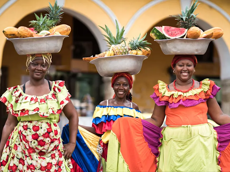 Cartagena, traditioneller Kleidung, Kolumbien Drei Frauen in traditioneller kolumbianischer Kleidung mit Früchteschalen auf den Köpfen. Cartagena, Bolívar, Kolumbien.