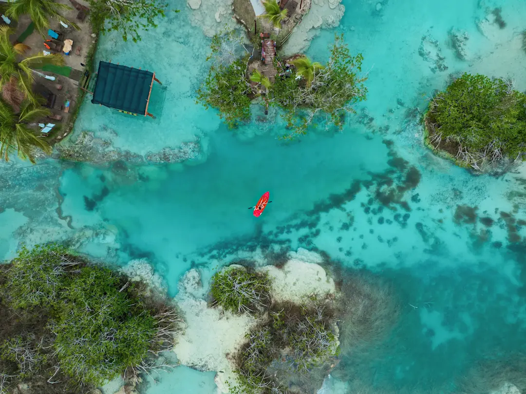 Rotes Kajak auf türkisblauem Wasser. Bacalar, Quintana Roo, Mexiko.
