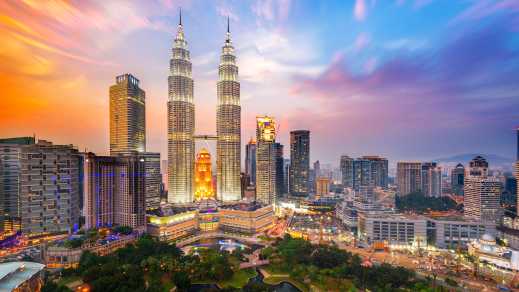 Vue sur les gratte-ciel et les tours Petronas éclairées au coucher du soleil à Kuala Lumpur, en Malaisie