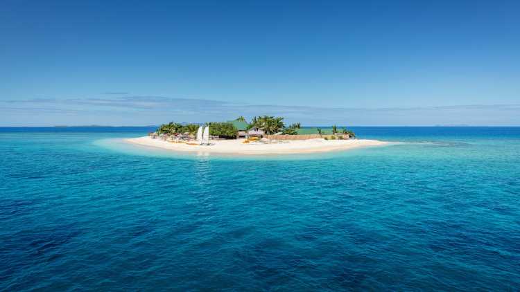 South Pacific Islands, Fiji,  view of Mamanuca Island from offshore surrounded by peaceful waters.