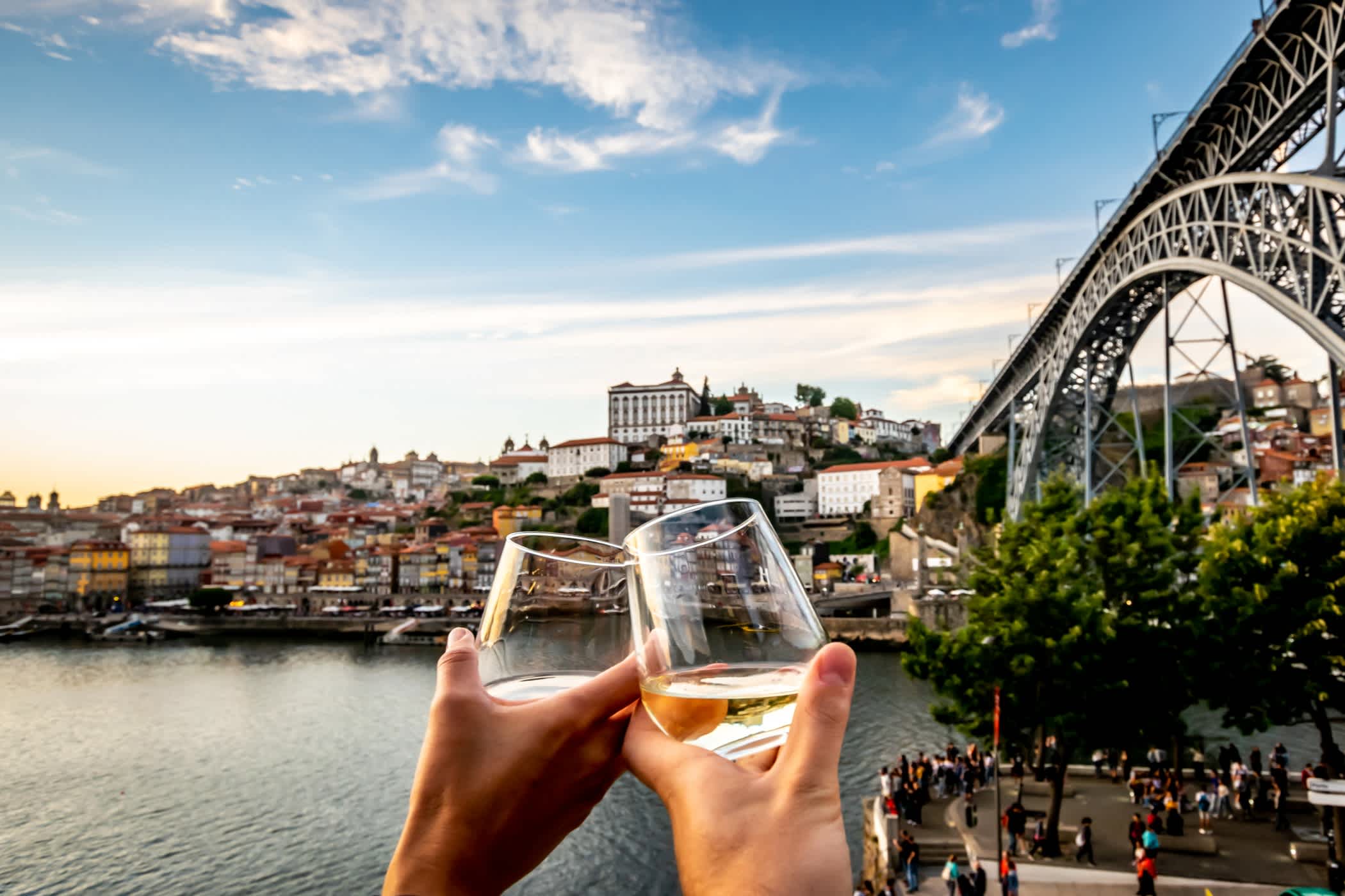 Weingläser vor einer Brücke und dem Fluss Douro in Portugal