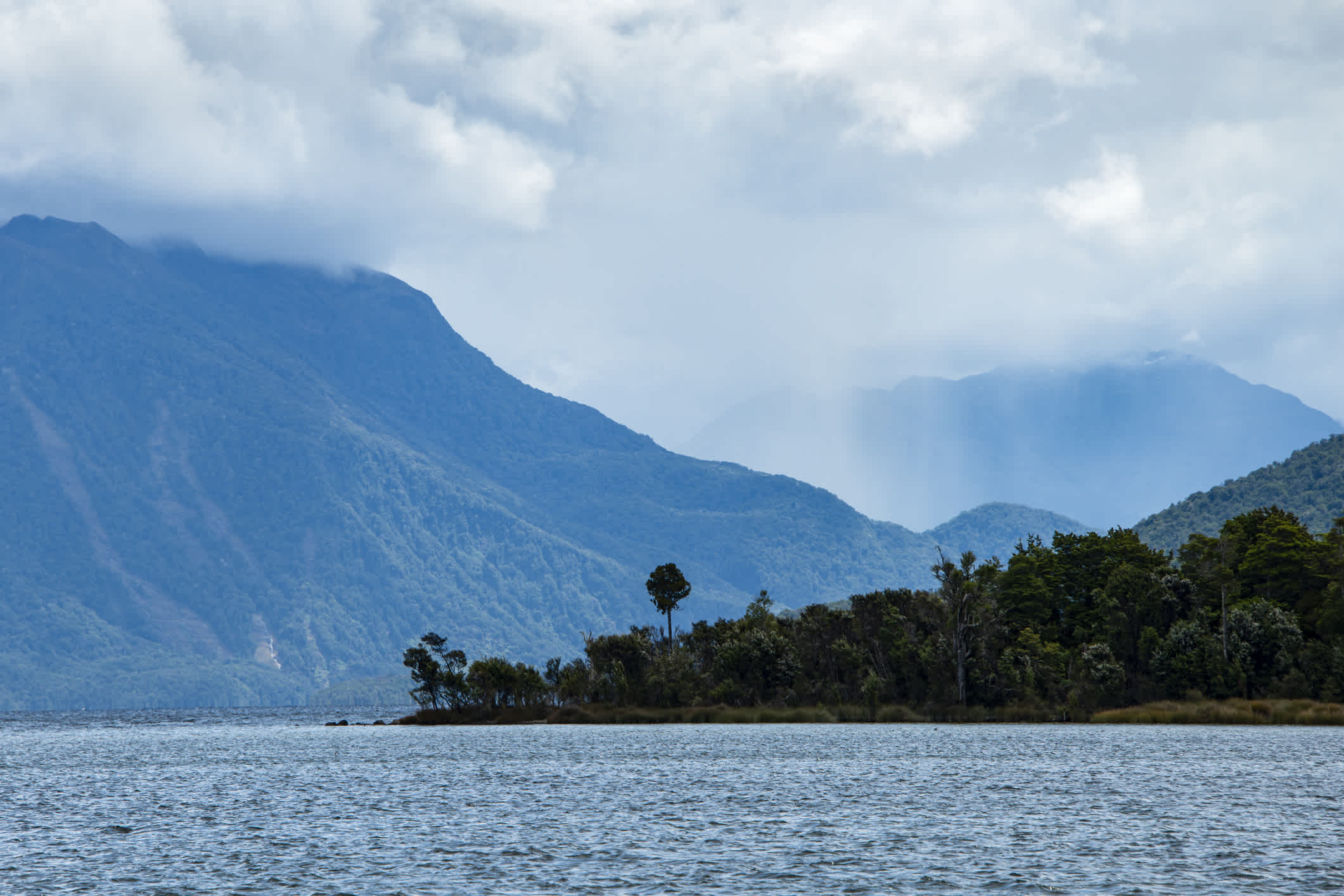 Lac de Te Anau et chaînes de montagnes dans le brouillard, île du Sud, Nouvelle-Zélande.