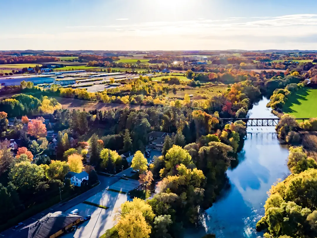 Flusslandschaft mit Brücke und bunten Bäumen im Herbst. Stratford, Ontario, Kanada.
