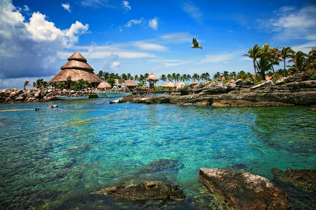 Türkisfarbenes Wasser und Strohbungalows in Cancún, Mexiko